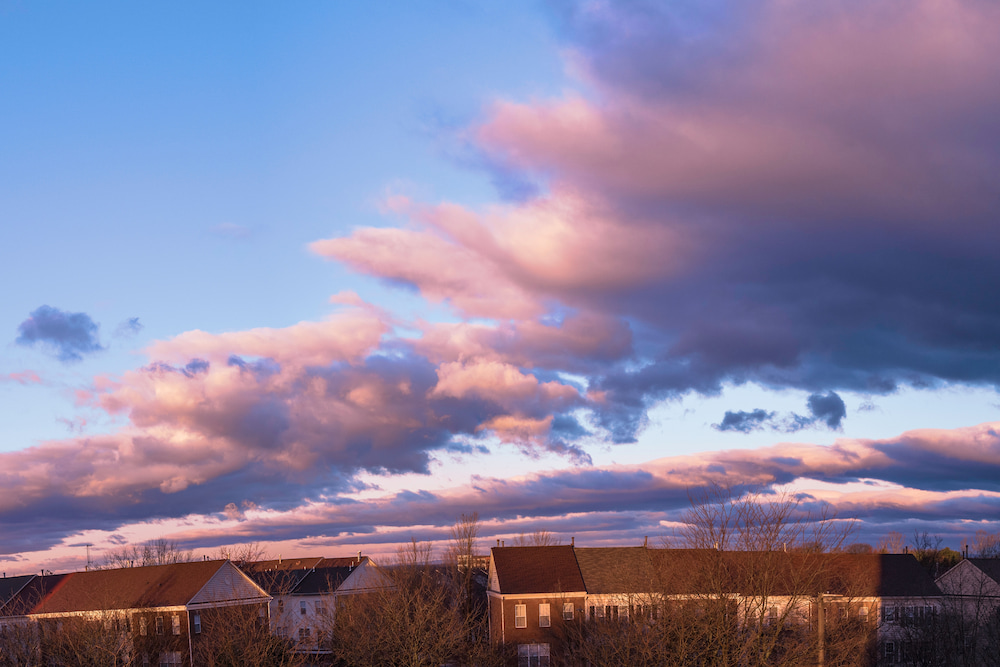 Dramatic cloudscape over the barren trees and houses after winter rain storm in Gaithersburg, Maryland